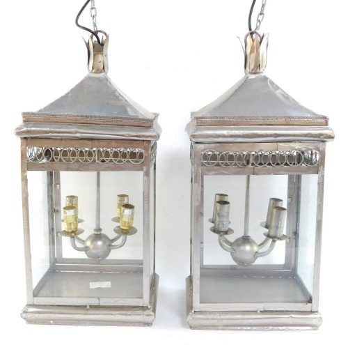 Two wrought iron hanging lanterns, each with four branch central section, and hanging strand, converted to electricity, 58cm high, in silver.