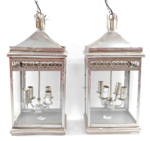 Two wrought iron hanging lanterns, each with four branch central section, and hanging strand, converted to electricity, 58cm high, in silver.