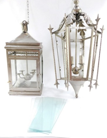 Two silvered finish hanging lanterns, to include a hexagonal large coaching lantern with acanthus leaf hexagonal top and base with four branch arm converted to electricity, together with a rectangular box lantern in silvered finish, 56cm high. (2)