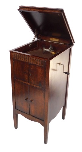 A Lavette oak cased cabinet gramophone, the levered top gramophone section over a two door enclosed sound box, over two further doors, raised on tapering square legs, 93cm high, 42cm wide, 47cm deep.