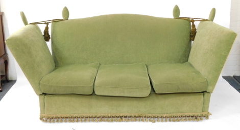 A Knole three seater settee, with loose cushion seats, raised on castors, 204cm wide.