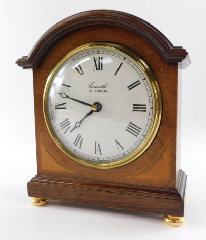 A Comitti of London Edwardian style mantel clock, circular white dial bearing Roman numerals, quartz movement, the case of domed form with paterae inlay, raised on brass bun feet, 20cm high, 15cm wide, 16cm deep.