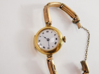 A 9ct gold cased wristwatch, with small circular wristwatch head, on white enamel back, with Roman numerals and blue hands, on a later rose gold bracelet, with safety chain, the watch head 2.5cm wide, 15.4g all in. - 2