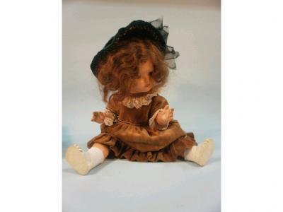 An early plastic crying doll wearing a brown dress