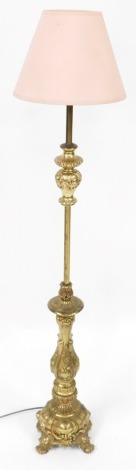 A brass standard table lamp, with rococo formed scroll supports, and pink material shade, 120cm high.