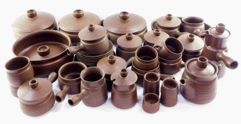 A brown stoneware part dinner service, with horizontal fluting, including tureens, chocolate pots, side plates, egg cups, etc. (4 trays)