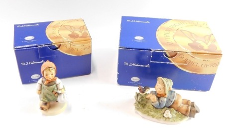 Two Goebel Hummel figures, comprising Grandma's Girl, and figure group of boy seated with a bird, boxed.