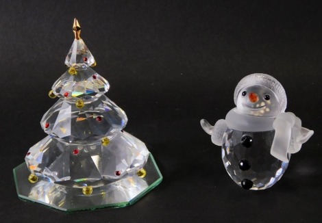 Two Swarovski crystal Christmas ornaments, comprising a snowman and Christmas tree, boxed. (2)