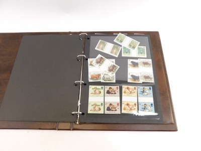 Philately. A Royal Mail stamp album containing unused UK stamps, boating and lighthouse scenes, religious scenes, college building press, bulls, etc., together with an empty green album. (a quantity) - 2