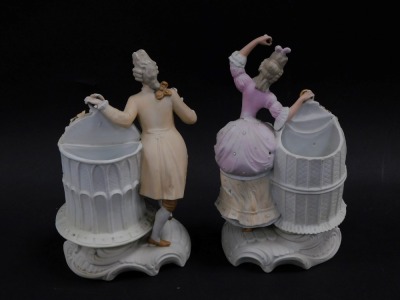 A pair of continental late 19thC bisque porcelain figures, of a gallant and lady, each modelled standing aside a birdcage holding a cockatiel and parrot respectively, raised on a rococo scroll base, impressed marks, 23cm high. - 2