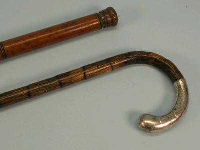 A bamboo walking cane with a part silver handle