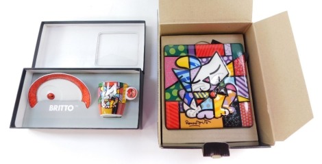 A Goebel Britto blue cat plaque, designed by Romero Britto for Artists Orbis 2010, together with a similar demitasse coffee cup and saucer, both boxed. (2)