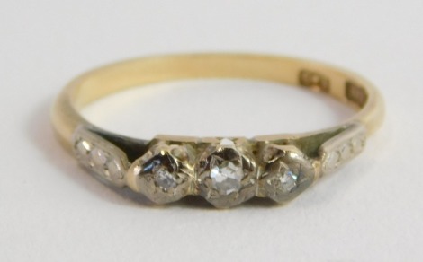 An 18ct gold platinum and diamond three stone ring, high claw illusion set, size N, 2.4g.