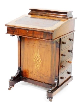 A Victorian walnut and marquetry inlaid Davenport, the hinged lid enclosing a fitted interior for pens, cards, etc., above a fall with a later hardwood inset panel enclosing a fitted interior above side drawers with turned wood handles, on a shaped platfo