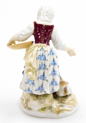 A Meissen porcelain figure group, of a young girl feeding cockerel, chicken and chicks, on a gilt highlighted circular base, blue cross swords mark to underside and impress number 115, 11cm high. (AF) - 2