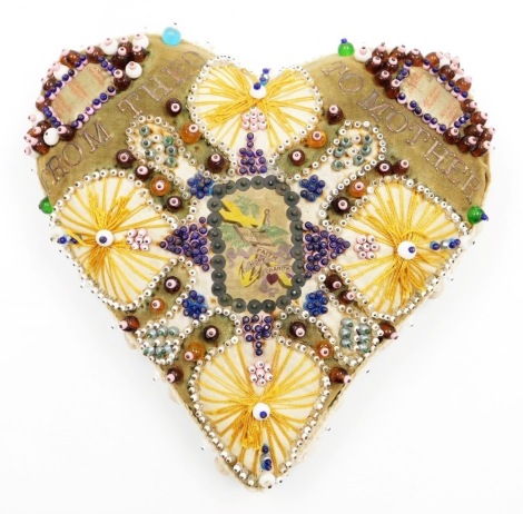 A heart shaped sweetheart pin cushion, with beaded panels and detailing with inscription 'From Theo To Mother,' with central Holy Bible Faith, Hope and Charity emblem, with white bubbled outer border, 27cm high.