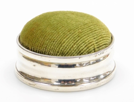 A late 19th/early 20thC silver collared pin cushion, with a sage green corded top, the leather base stamped RD No 520361, hallmarks rubbed, 8cm diameter.