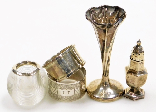 A collection of small silver, a late Victorian miniature silver pepper pot, of baluster form with an urn shaped finial on a pedestal base, Birmingham 1899, a silver bud vase with a flared twisted rim, Sheffield 1899, two napkin rings and a glass match str