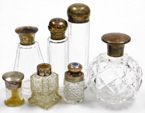 A collection of cut glass and silver topped dressing table bottles, to include a George V perfume bottle with a silver top and simulated tortoiseshell inlay and stopper, Birmingham 1928, 13cm high, a cut glass perfume bottle of globular form, 11.5cm high,