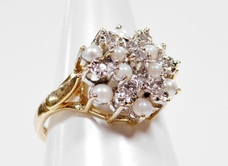 A 9ct gold dress ring, with central cluster design, set with seed pearls and cz stones, with star point decoration on a raised basket, ring size L, 3g all in.