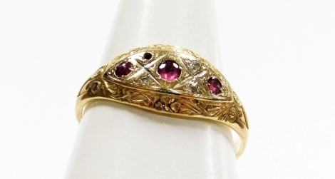 An 9ct gold Victorian style dress ring, the centre set with three garnets and four diamonds (one missing), the outer border with scroll overall detailing, ring size N, 2g all in.