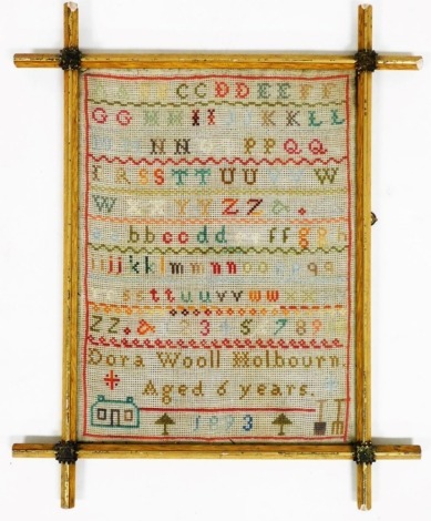 A late 19thC wool work alphabet sampler, by Dora Wool Holbourn aged 6 years, dated 1893, in a gilt wood frame, 35cm x 26cm.