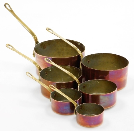 A graduated set of brass and copper saucepans, each with pierced handles and plain bodies, possibly French, 8cm high, etc. (6)