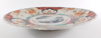 Four Japanese Imari dishes, of fluted form, decorated with reserves of flowers, Meiji period, 21/22cm diameter. (AF) - 14