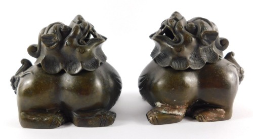 A pair of Chinese bronze incense burners, cast as dogs of fo with removable heads, bearing four character mark "Da Qing nian zhi", 12.5cm wide.