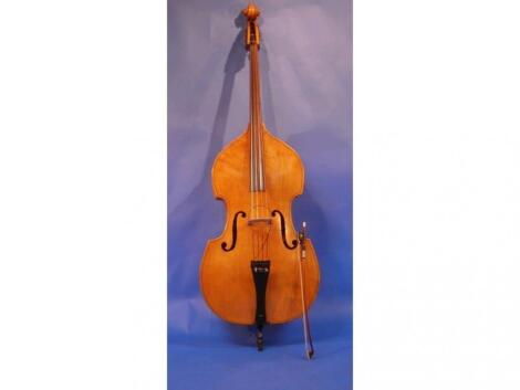 A double bass, with bow, converted with an electric pick up, with brass