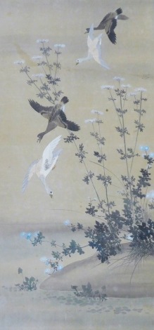 A Meiji period Japanese painting on silk, of ducks in flight over a riverbank, 101.5cm x 49cm.