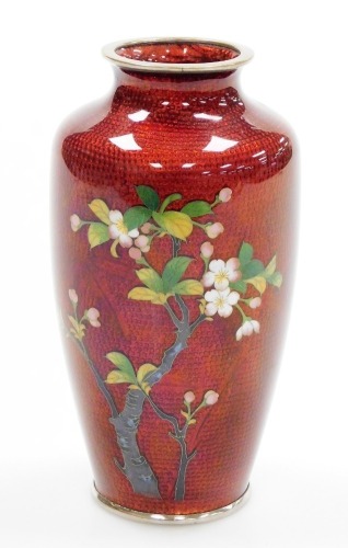 A 20thC Japanese silver wire cloisonné baluster vase, decorated with a prunus branch on a translucent red ground, 21cm high.