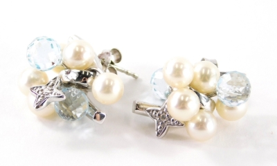 A pair of 18ct white gold pearl diamond and blue topaz earrings, each of cluster designs set with two blue topaz and five pearls with a diamond set star drop, on single pin back with butterfly backs, 2.2cm high, 10.9g all in.