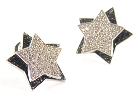 A pair of Wempe diamond and black diamond rotating star earrings, each pavè set with white diamonds to the front and black treated diamonds to the back star, peg and butterfly fitting backs, total estimated white diamond 0.95ct (146), total estimated blac