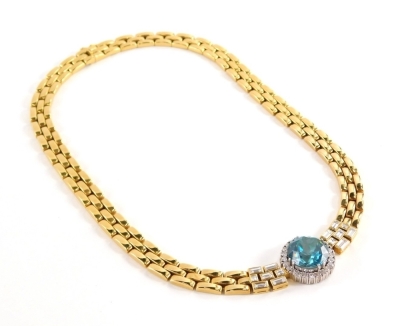 A blue zircon and diamond set necklace, with three row brick link necklets in yellow gold centre by a round brilliant cut blue zircon totalling 19.97cts, within a border of twenty four round brilliant cut diamonds, claw set in white gold, totalling approx