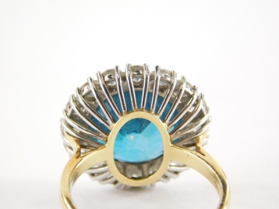 A blue zircon and diamond cluster ring, with central blue zircon totalling 13.1cts, within a border of sixteen round brilliant cut diamonds, in white gold setting totalling approx 1.6cts, on a yellow gold shank, 18ct gold, London 2006, with C Limited spon - 2