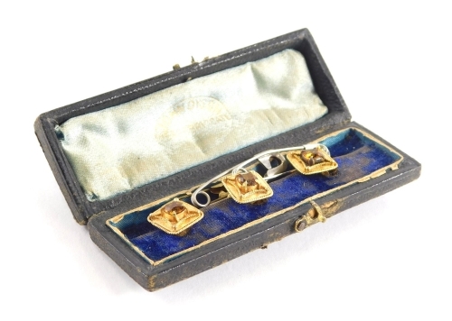 Three topaz set collar studs, each of square form with outer beaded detailing, bloom gold, 1cm x 1cm, boxed.