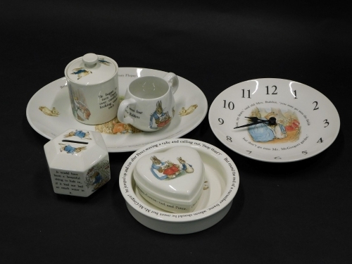 A collection of Wedgwood Peter Rabbit items, to include a two handled loving cup, money box, platter, bowl, wall clock, heart shaped trinket box and cover etc. (quantity)