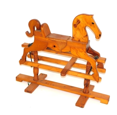 A pine rocking horse, with tan leather saddle, 90cm high, 95cm wide, 34cm deep.