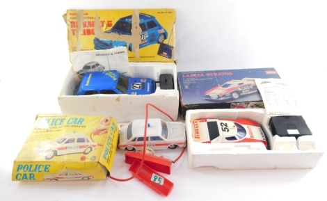 Remote controlled cars and rally cars, comprising a Schuco Radiograph Lancia Stratus 1:18 scale, with remote control, a Radio Shack Renault 5 Turbo, with remote control, and a Marx Toys remote controlled police car, battery operated, flashing light, all b