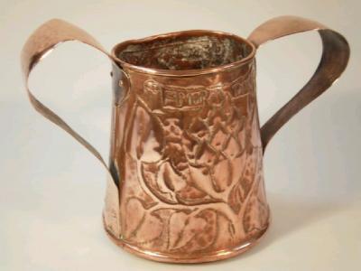 An Arts and Crafts large two handled copper loving cup with beaten decoration