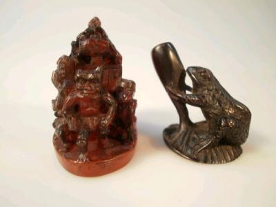 A carved hardwood netsuke of a toad on a lily pad