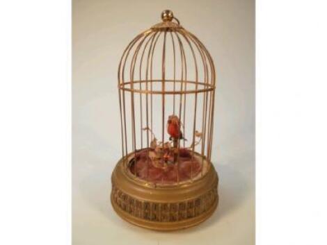 A wind-up automaton of a bird in a cage on cylindrical base and on ball feet