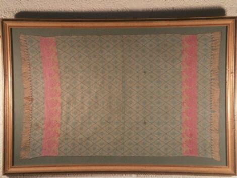 A framed fabric panel with swan borders and geometric patterns