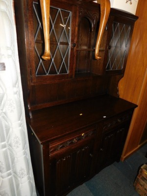 A dark oak dresser, with lead glazed cabinets.