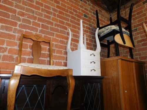 A pair of Nathan ebonised dining chairs, with birch ply back rests, and upholstered seats, together with an Ercol bedroom chair and a French style bedside chest. (4)