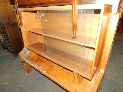 A teak bookcase, with sliding glass doors.