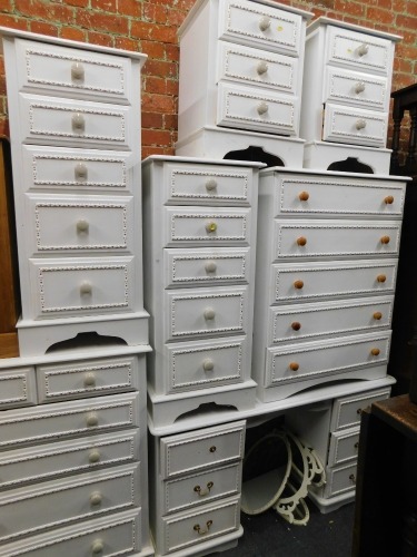 A white painted pine bedroom suite, comprising four chests of drawers, two bedside chests, dressing table and a mirror. (8)