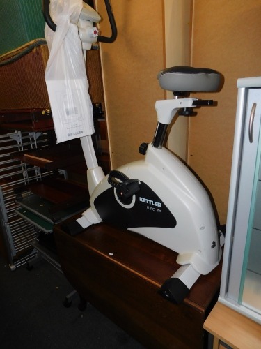 A Kettler exercise bike, together with a mid 20thC drop leaf table. (2)