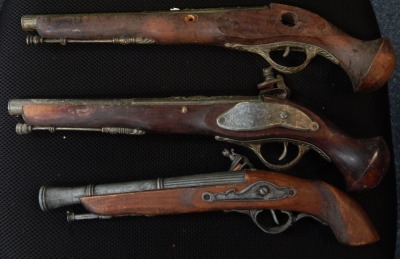 Three replica flint lock pistols.